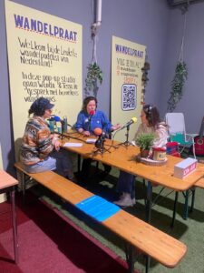 drie vrouwenszitten aan tafel en geven een podcast